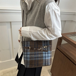 Retro plaid bucket bag for women with leather trim and shoulder strap in a side view