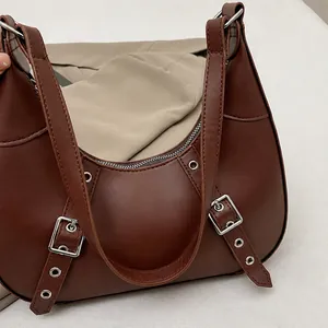 Detailansicht der braunen Hobo-Tasche mit silbernen Schnallen und Ösenriemen