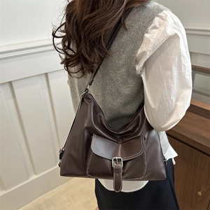 Sac hobo en similicuir marron foncé avec surpiqûres contrastées porté par un mannequin