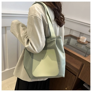Side view of large avocado green tote bag with front pocket and BUDBAO brand logo