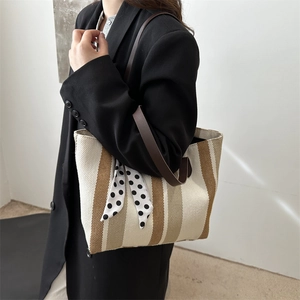 Striped canvas tote bag with silk scarf and brown leather strap for commuting