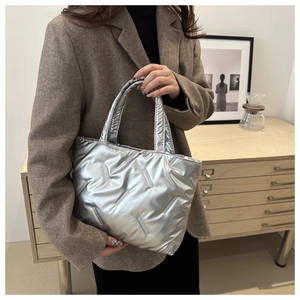 Detailed view of silver quilted tote bag with metallic texture and padded design