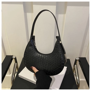 Detail of the intricate woven texture and silver zipper on the black crescent hobo bag