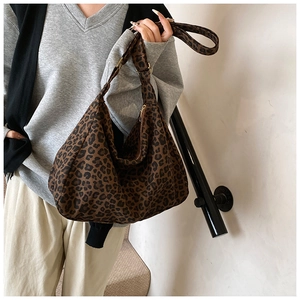 Close-up of leopard print canvas hobo bag with a zipper and long shoulder strap