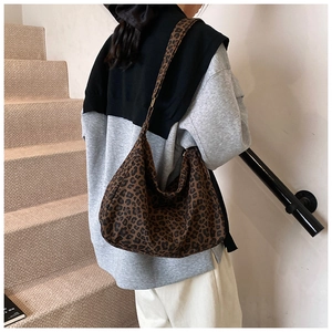 Detail of a soft leopard print bucket bag with wide shoulder strap in a streetwear style