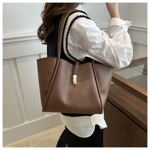 Borsa tote marrone caramello su modella che mostra dimensioni e trama in pelle opaca