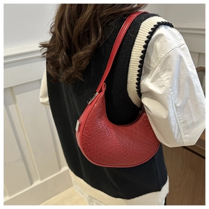 Détail du sac à bandoulière demi-lune en cuir tressé rouge avec fermeture éclair argentée