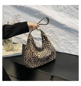 Detail of hobo shaped shoulder bag featuring classic leopard print and smooth zipper