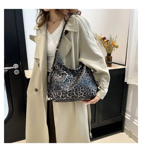 Detailed view of large leopard print hobo bag worn with a stylish beige trench coat