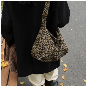 Detail of leopard print tote bag with adjustable bronze metal buckle and casual texture