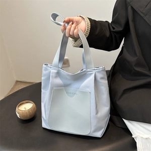 Light blue large capacity nylon tote bag with leather front pocket and sturdy top handles