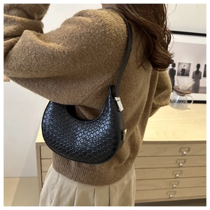 Détail de la texture tissée et boucle argentée sur le sac bandoulière demi-lune noir