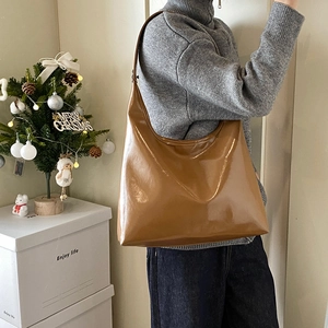 Brown glossy leather tote bag shown in a cozy home setting for casual style