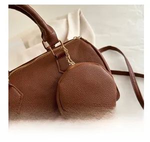 Detail of dark brown pebble leather Boston bag with matching circular coin purse charm