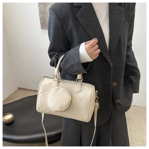 Detail of off-white lychee leather Boston bag with a matching coin purse and gold hardware