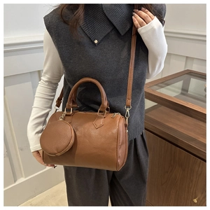 Close-up of brown litchi pattern leather Boston bag with matching round coin purse detail