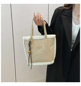 Détail du sac cabas en polaire beige avec bordure en fausse fourrure et breloque dorée