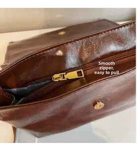 Detail of smooth golden metal zipper and magnetic closure on vintage oil wax leather bag