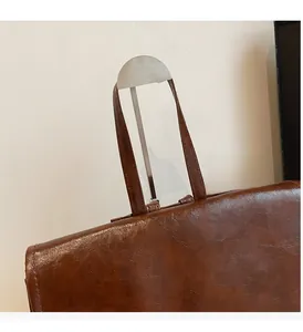 Close-up of the vintage brown faux leather handle with cylindrical metal connectors