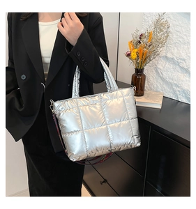 Détail du sac cabas matelassé argenté avec une large bandoulière tissée colorée