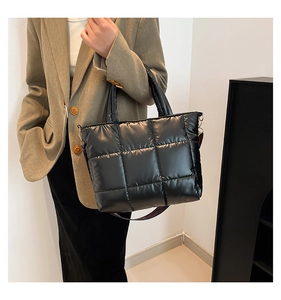 Détail d'un sac cabas matelassé noir avec une large bandoulière géométrique colorée