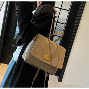 Side view of a vintage brown leather backpack worn by a model in casual professional attire