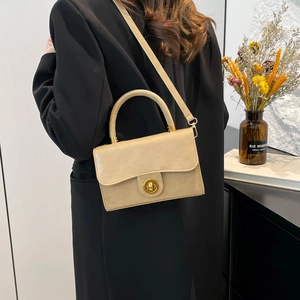 Chic beige retro crossbody bag with a gold round twist lock and elegant top handle