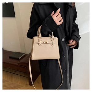 Détail du sac bandoulière beige avec fermoir doré et texture haut de gamme
