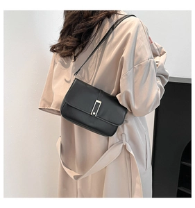 Detail einer minimalistischen schwarzen Lederumhängetasche mit elegantem Metallschnallenverschluss
