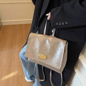 Modern light khaki convertible backpack handbag in glossy leather with gold nameplate