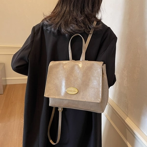 Retro taupe leather backpack for women with gold metal logo and minimalist design