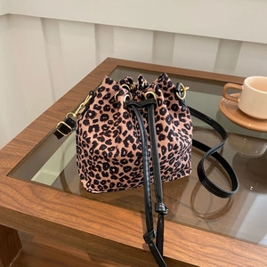 Detail der Leopard-Beuteltasche mit schwarzem Leder-Kordelzug auf einem Holztisch