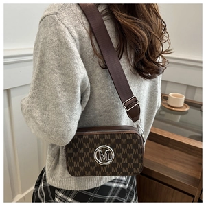 Rear view of a vintage brown crossbody camera bag with M-pattern and wide strap