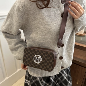 Brown letter print crossbody bag with silver hardware and wide nylon strap on model