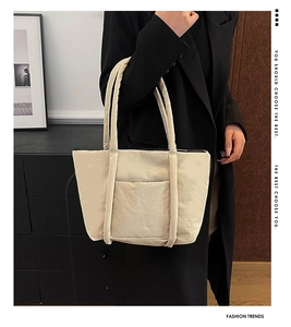 Close-up of beige large capacity tote bag featuring textured fabric and durable straps