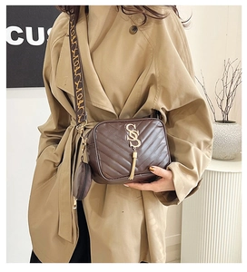 Close-up of brown quilted chain camera bag with golden S logo and patterned strap