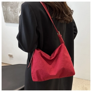 Detail of red suede hobo shoulder bag with adjustable gold buckle and elegant silhouette