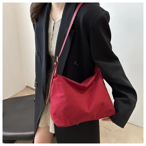 Detailed view of red suede nylon hobo bag with a minimalist vintage design on model