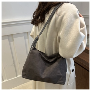 Close-up of large dark grey suede tote bag with soft texture and adjustable strap