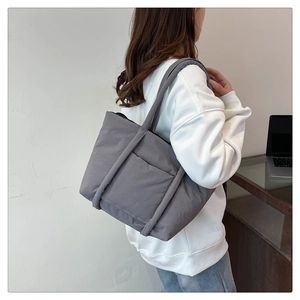 Side view of a large dark grey quilted tote bag showing waterproof fabric and stitching