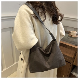 Detail of vintage grey hobo shoulder bag with wide strap paired with a long wool coat