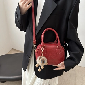 Red vintage matte leather mini Boston handbag with adjustable strap and alpaca charm