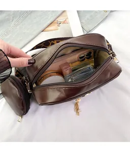 Detail view of deep brown crossbody bag interior showing spacious storage and mini pouch