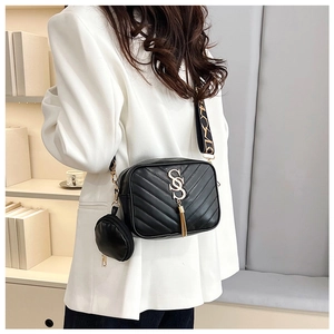 Detail of black quilted camera bag with gold hardware, fringe, and round coin purse