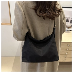 Detail of adjustable black canvas shoulder strap and metallic buckle on minimalist bag