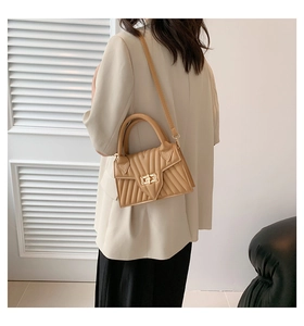 Detail of the camel shoulder bag with V-shaped quilted texture and gold turn-lock closure