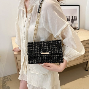 Elegante schwarz-weiße Tweed-Umhängetasche mit Goldkette und goldenem Metallverschluss