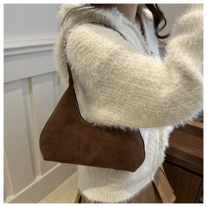 Detail of vintage matte brown suede shoulder bag with sleek silver zipper and metallic studs
