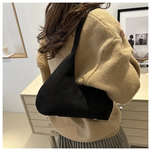 Detail of matte suede shoulder bag featuring silver metal feet and durable curved design