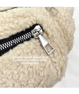 Detail of silver smooth hardware zipper on beige fuzzy lamb wool belt bag